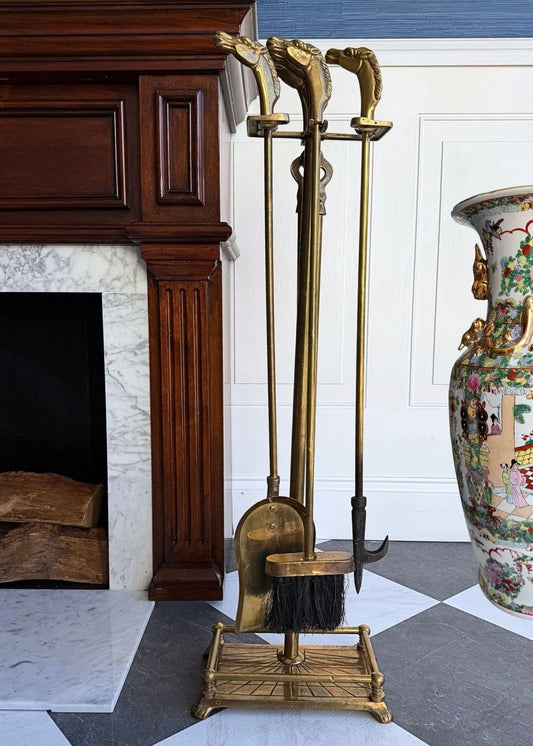 Brass fireplace tools set against a decorative vase and marble fireplace.